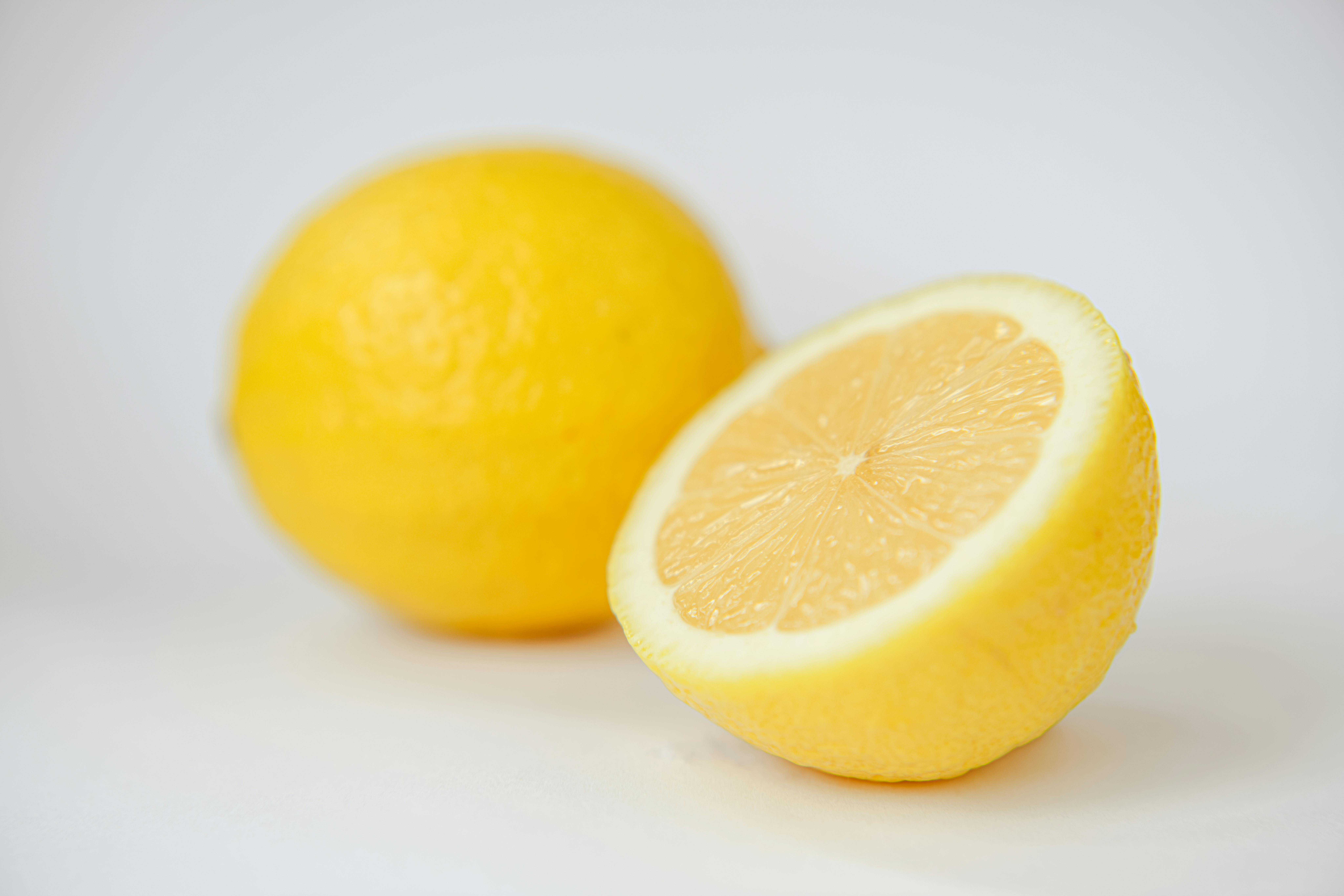 Citron frais coupé en deux utilisé comme remède naturel avec sel ou bicarbonate pour détacher un t-shirt blanc taché en douceur sans abîmer les fibres du tissu